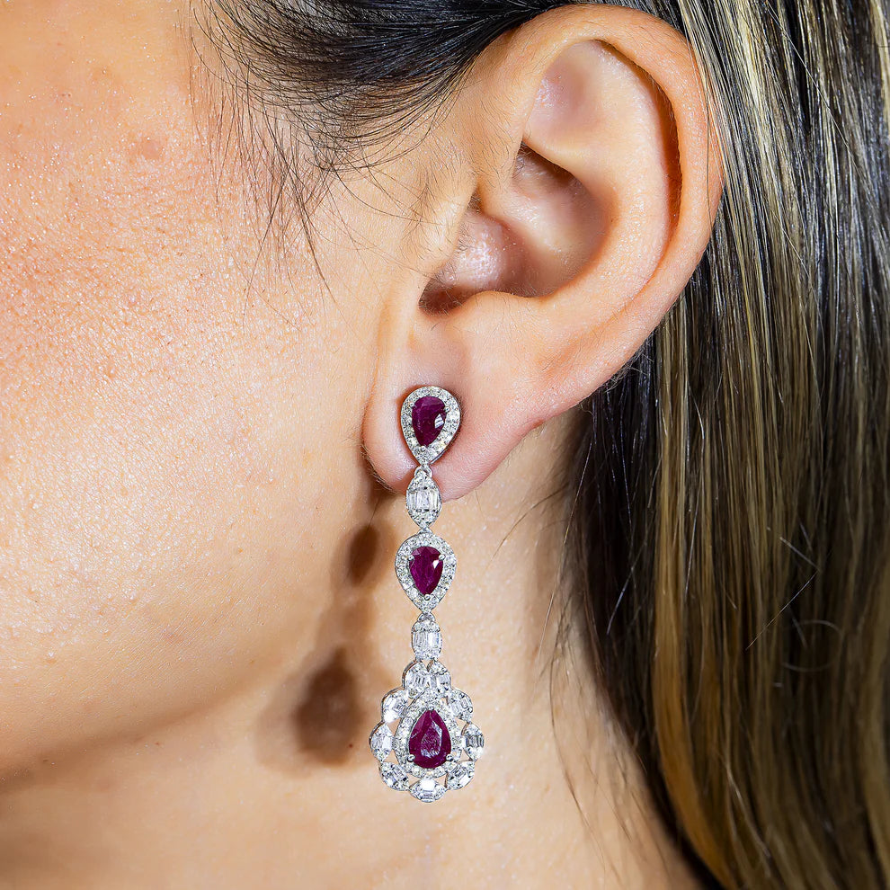 A woman wearing the Baylor Ruby & Diamond Three Tier Drop Earrings