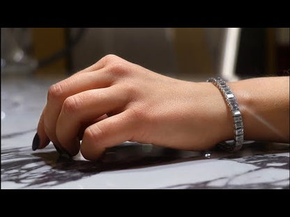 Video of an Emerald Cut diamond tennis bracelet containing 19.43 / 19 Carats of Lab Grown diamonds on a models wrist featured on a beautiful marble countertop